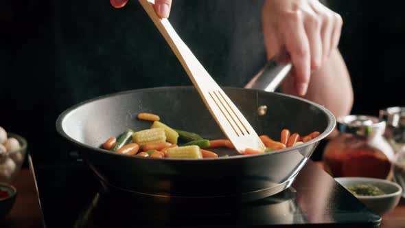 Chef Frying Vegetables in Pan Closeup