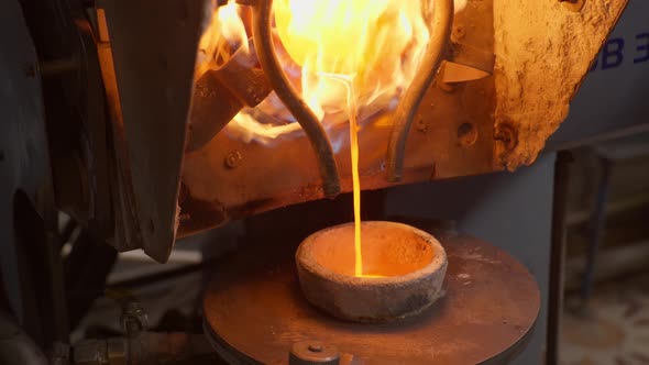 Close Up at the Molten Silver Pouring Into the Smelter Bowl at the Plant for Production Items Out of