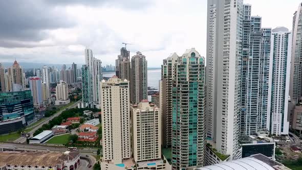 Aerial drone footage of buildings in Panama City in front of the sea with camera panning