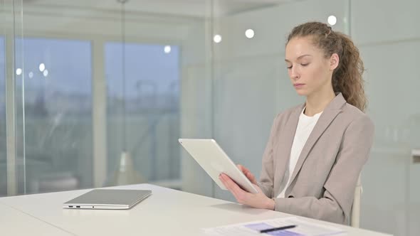 Hardworking Young Businesswoman Using Tablet in Modern Office