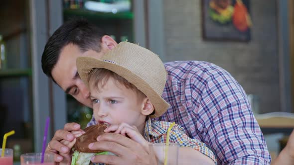 Malnutrition, Little Cute Male Child Eats Fast Food Hearty Meat Burger with His Loving Father During