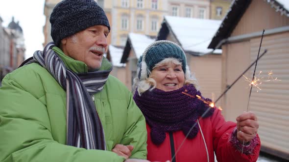 Senior Happy Couple with Burning Sparklers Bengal Lights Celebrating Birthday on City Center Street