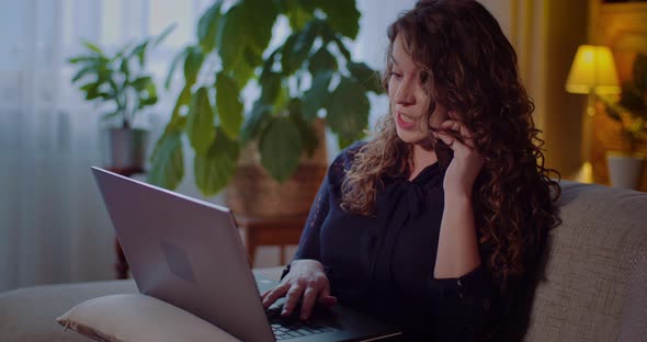 Portrait of Businesswoman Working on Laptop While Talking on Mobile Phone