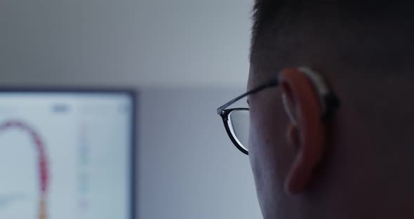 Closeup of Part of the Head of a Man in Glasses Looking at a Screen