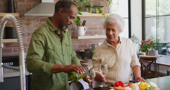 Senior African American husband and mixed race wife cooking together at home