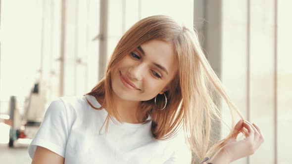 Portrait of beautiful smiling blond model dressed in summer hipster white t-shirt