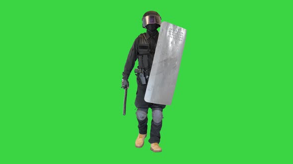 Heavily Armored Policeman with a Shield and a Baton Walking on a Green Screen Chroma Key