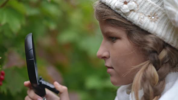 Closeup Side View Teenage Female Botanist Exploring Nature with Magnifying Glass Outdoors on Autumn