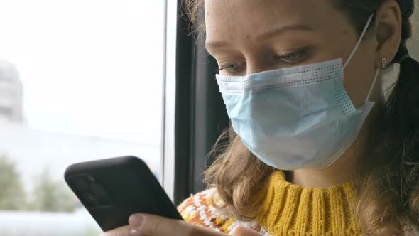 Woman in Mask Surfs Internet with Phone in Transport