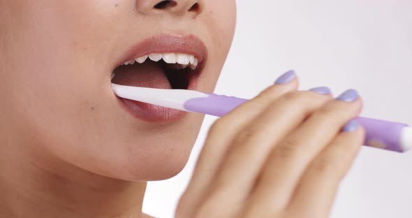 Close Up Shot of Young Woman Brushing Her Teeth White Studio Background Free Space