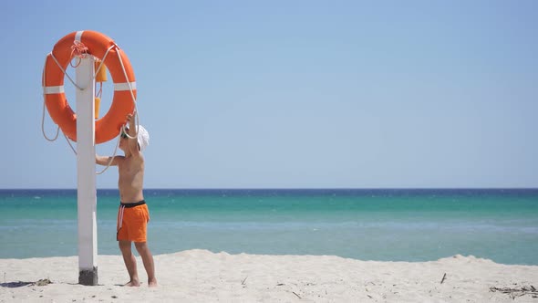 Orange Lifebuoy Hanging From a Pole on the Beach