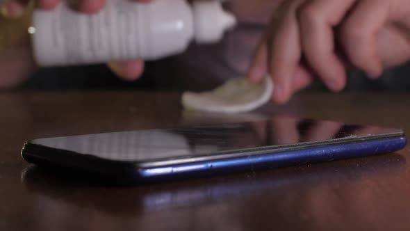 Guy Pours Disinfectant Drop on Mobile Following Precautions