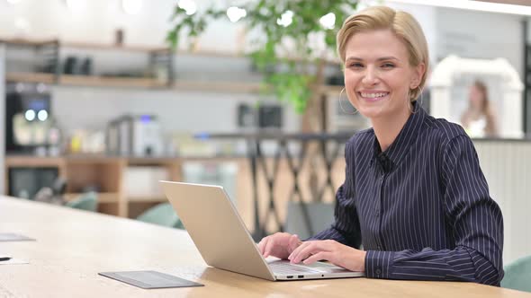 Cheerful Young Businesswoman with Laptop Smiling at Camera 