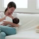 Mother breast feeding baby on sofa - VideoHive Item for Sale