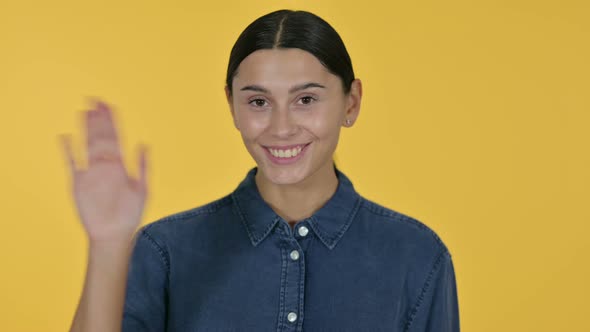 Welcoming Latin Woman Waving, Yellow Background 