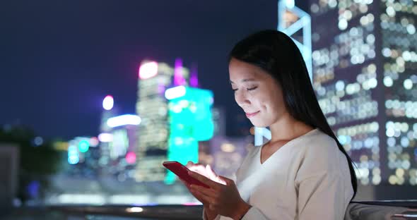 Woman use of mobile phone in Hong Kong at night