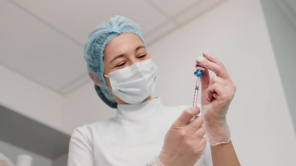 Nurse Draws the Vaccine Into the Syringe and Prepares for the Vaccination