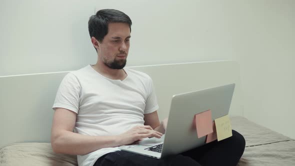 Man Is Chatting in Internet Sites, Using Laptop, Sitting in Bedroom