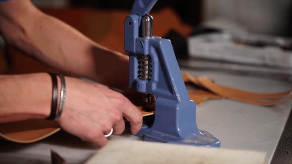 Craftsman Is Using Hand Press for Installing Metal Fittings on a Leather Good