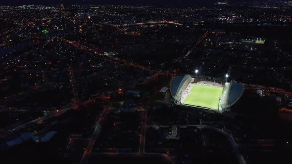Amazing Aerial Shot of Bright Football Arena Contrasting with Night City