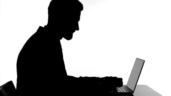 Silhouette of Angry Man Working on Laptop and Getting Stressed