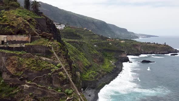 Aerial drone view of a steep, volcanic and rugged coastline. Recorded next to Gordejuela ruins in Te