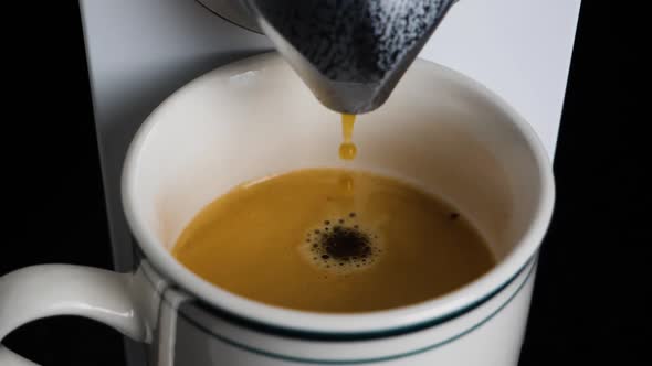 Slow motion shot of coffee drops dropping into a mug.