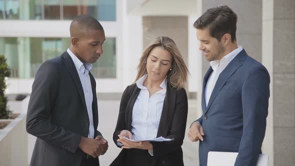 Young Business People Discussing Documents Outdoor