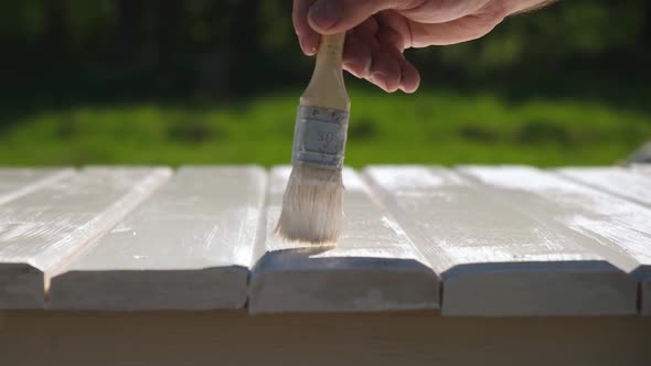 Man Painting Wooden Table Outdoors