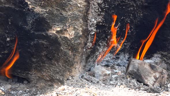 Flame of Methane Underground Emerges From Crack Between Rocks and Burns to Earth