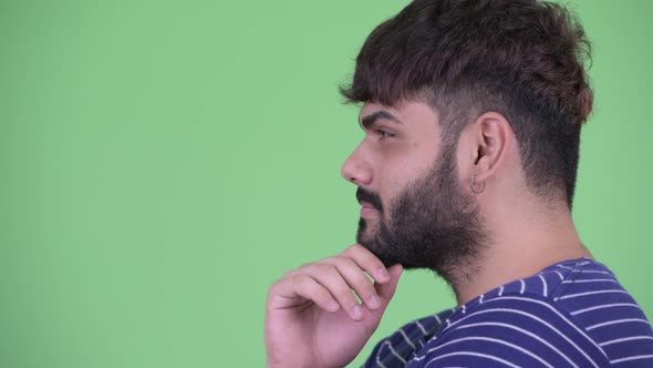 Closeup Profile View of Happy Young Overweight Bearded Indian Man Thinking