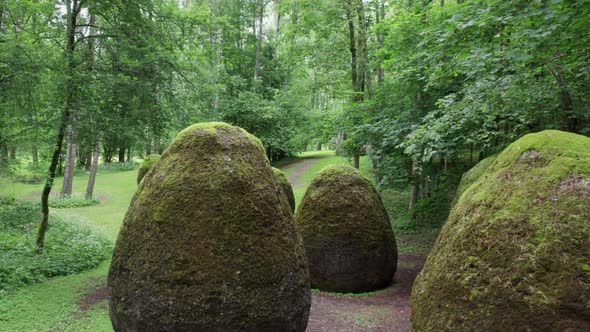 slow drone overflight rocks in the form of huge eggs overgrown with moss Europe park near Vilnius Li