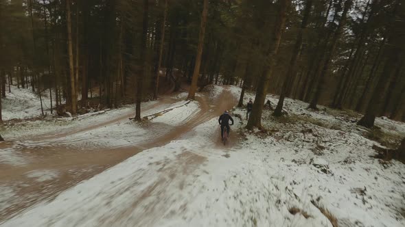 Drone Following Mountain Biker Leaping Over Hills