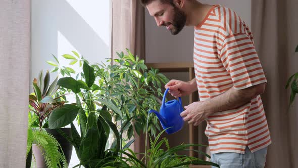 Happy Smiling Man Watering Flowers at Home