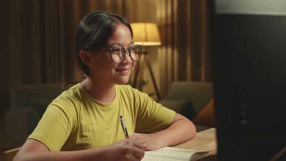 Asian Girl Student Distance Learning And Writing With Computer From Home