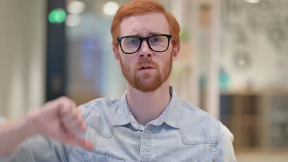 Portrait of Disappointed Casual Redhead Man Doing Thumbs Down 