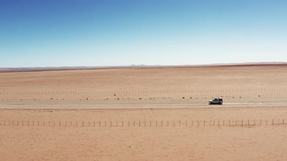 4x4 Safari Vehicle Travelling Across The Desert Of Namibia On A Sunny Weather. drone tracking shot