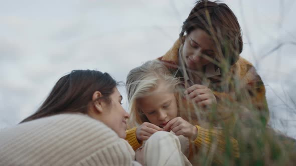 Two Lesbians Resting on Green Nature with Pretty Daughter