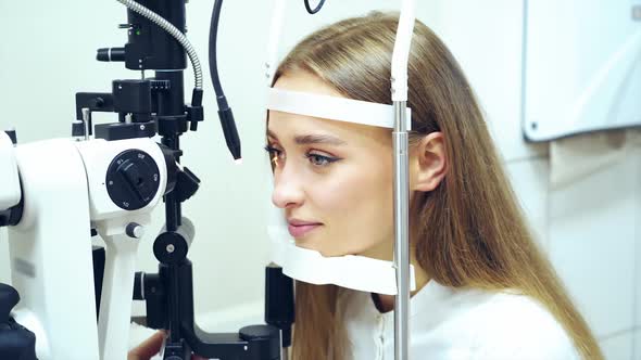 Young woman checking her eyes in clinic