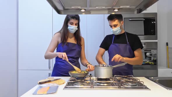 Happy young couple have fun in modern kitchen indoor while preparing vegetables food for lunch.