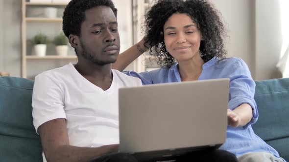 African Couple Using Laptop at Home