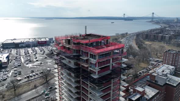An aerial view above Shore Parkway and a high-rise construction site in Brooklyn, NY in the day. The