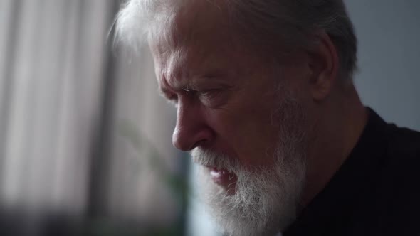 Closeup Headshot of Grayhaired Upset Depressed Mature Adult Man Crying Alone at Home Thinking of