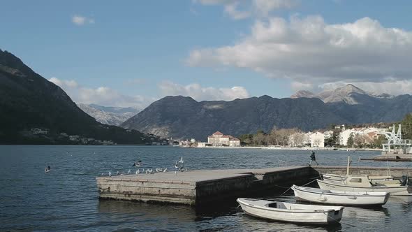 Motor boats on the shore on the background of the mountains in Montenegro in winter