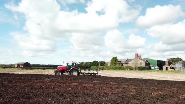 Aerial footage over tractor ploughing field