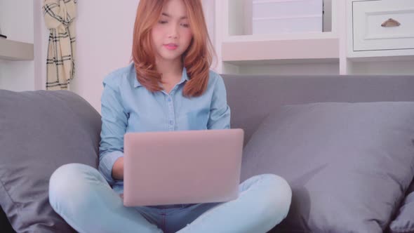 Asian woman working on laptop in living room,  beautiful female feeling tired sleeping after work.