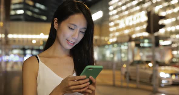 Woman using mobile phone at street 