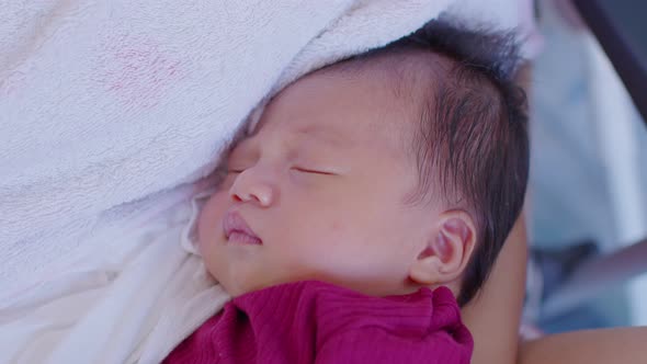 Adorable sleeping newborn baby relax in mother arm safety and comfortable