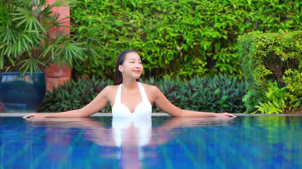 Young asian woman enjoy around outdoor swimming pool for leisure