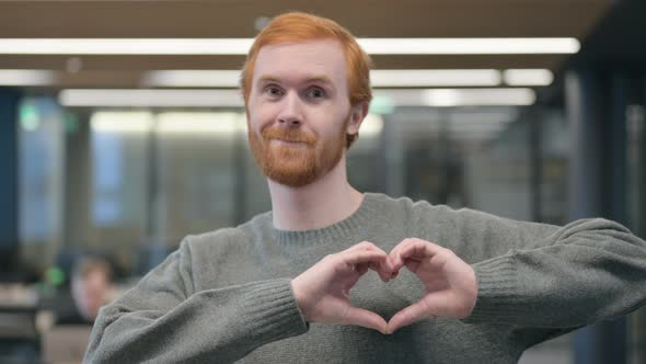 Portrait of Young Man Showing Heart Shape By Hands